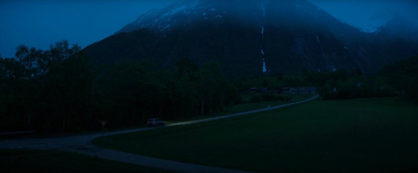 Car on Norwegian road at nighttime.