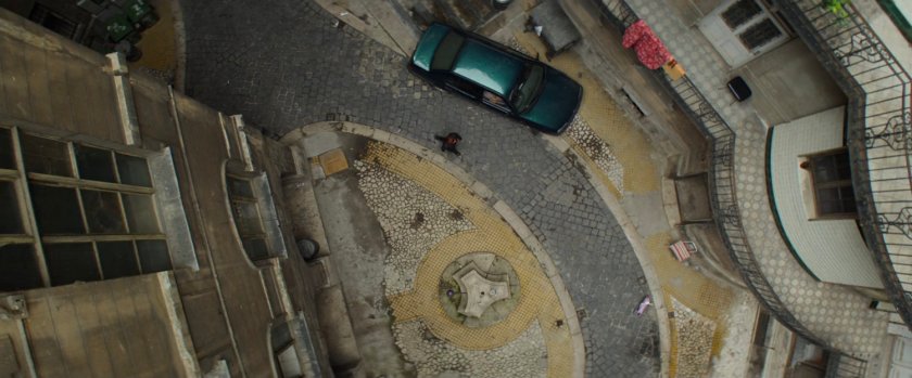 Aerial view of apartment courtyard with car.