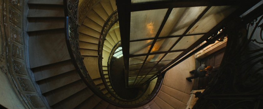 View down central staircase and elevator column in apartment building.
