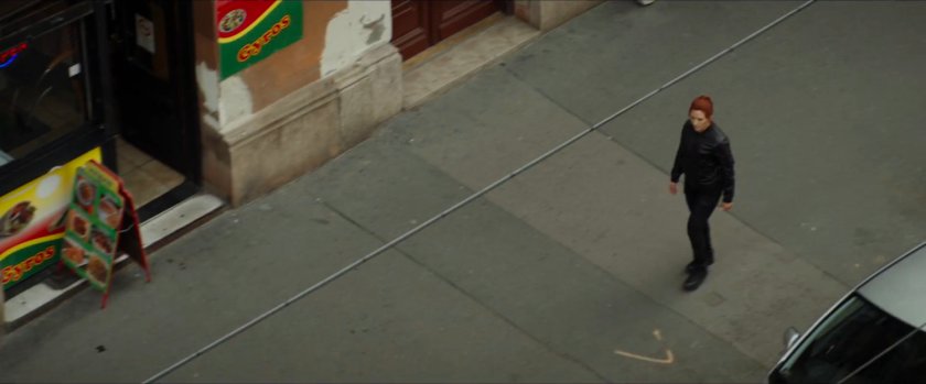 High angle of Natasha walking on Budapest sidewalk.
