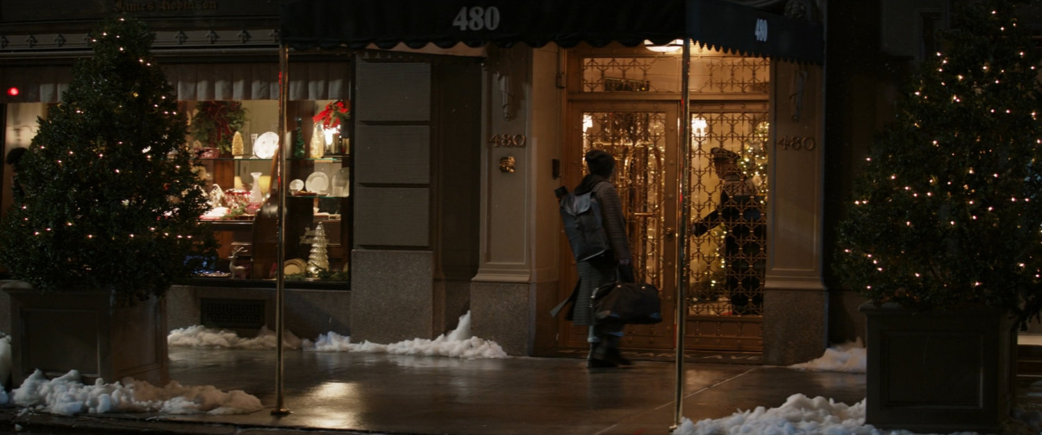 Kate walks along sidewalk outside Bishop Penthouse building.