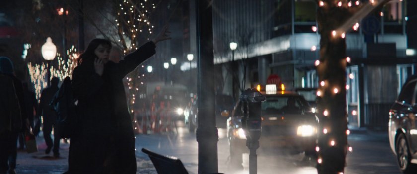 Kate hailing a taxi cab from a New York sidewalk.