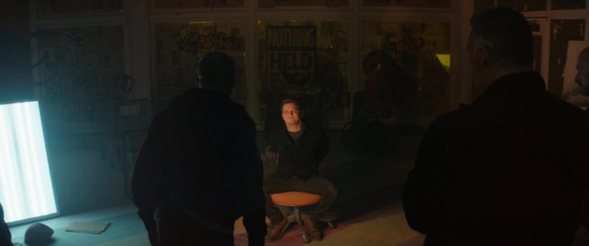 Clint surrounded by tracksuit mafia members in abandoned toy store.