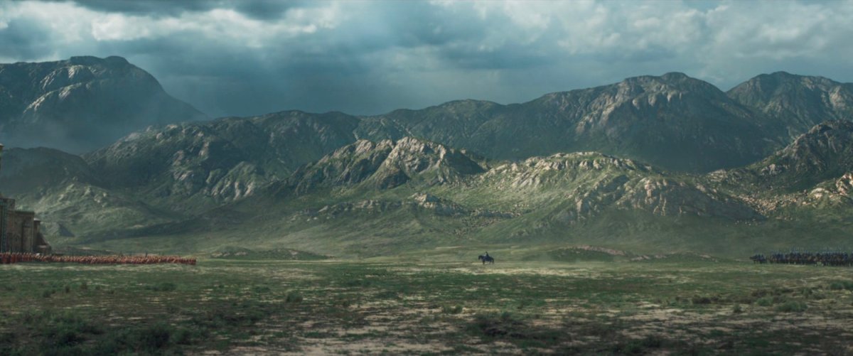Wide angle of battle plain with mountains in background as two armies face each other.