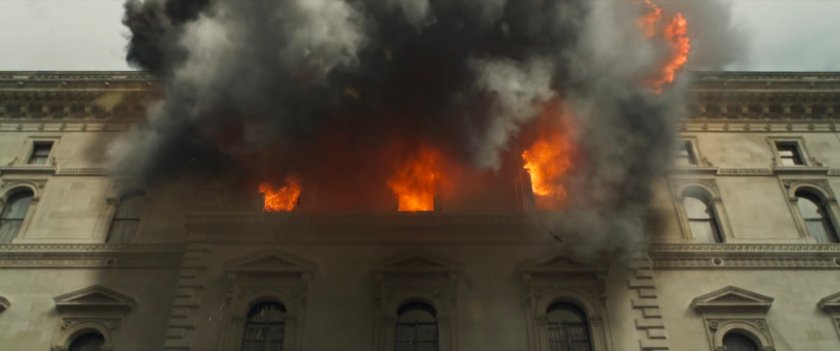 Looking up at government building as flames and smoke leap out windows.