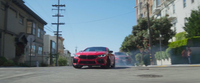 A red car skidding on a street in San Francisco.