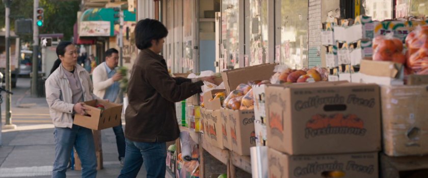 Sidewalk with workers stacking boxes filled with fruit in San Francisco.