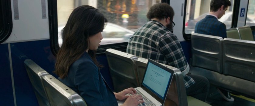 A woman working on a laptop on a San Francisco metro bus.