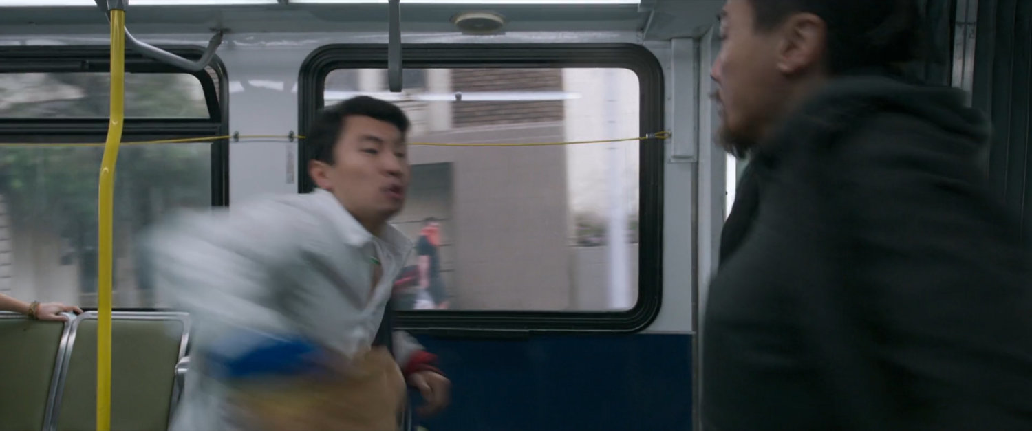 Shaun whips his jacket around on a San Francisco metro bus.