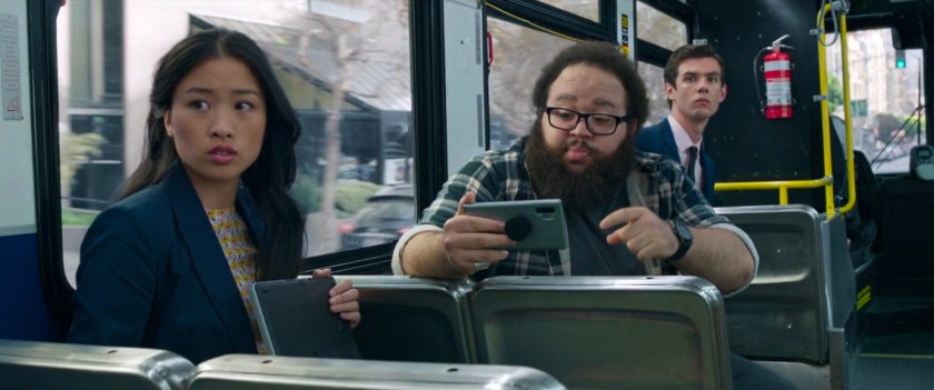 A woman and two men look on at the fight on a San Francisco metro bus.