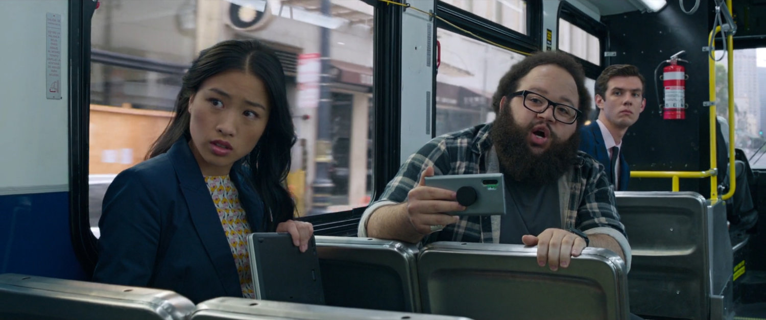 A woman and two men look on at the fight on a San Francisco metro bus.