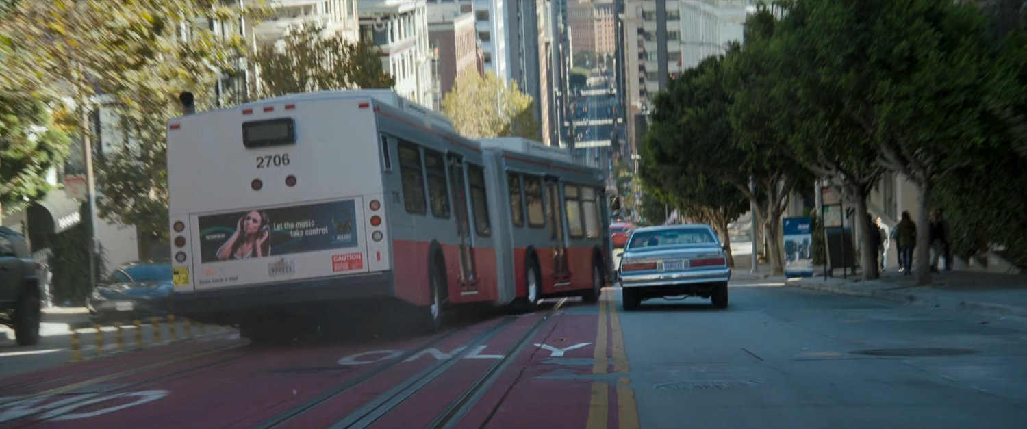 Exterior of San Francisco metro bus swerving down street.