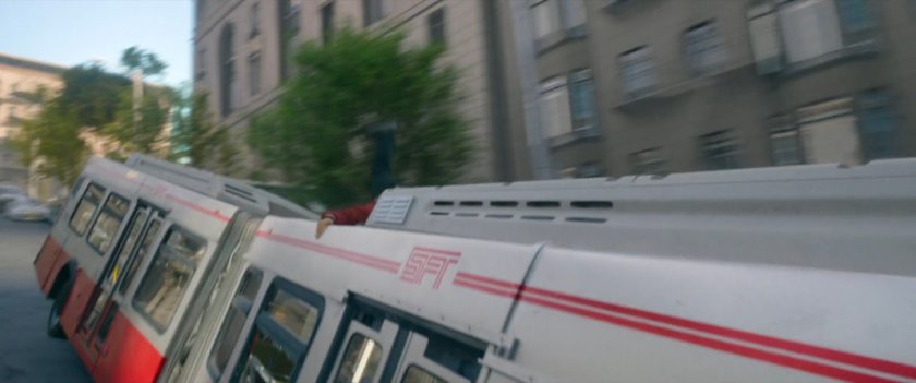Shaun climbs on the outside of a San Francisco metro bus.