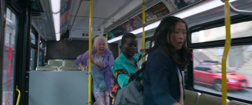 Passengers run towards the front of a San Francisco metro bus.