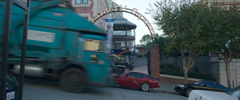 San Francisco trash truck speeding past Ghirardelli Square entrance.