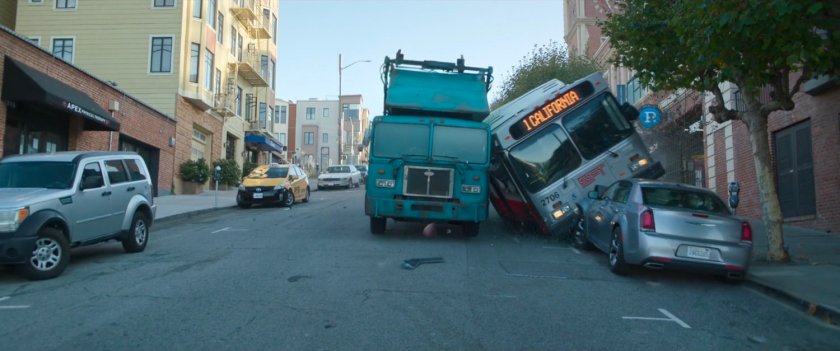 San Francisco trash truck and city bus stopping outside Ghirardelli Square entrance.