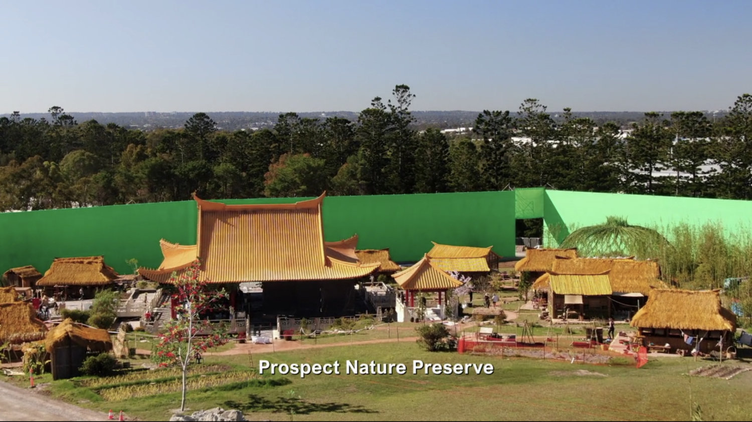 Behind the scenes of the village set with green screen behind it. Text: Prospect Nature Preserve.