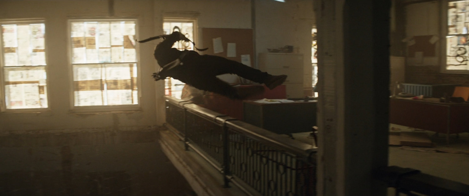 Clint diving off a balcony in an abandoned toy store.