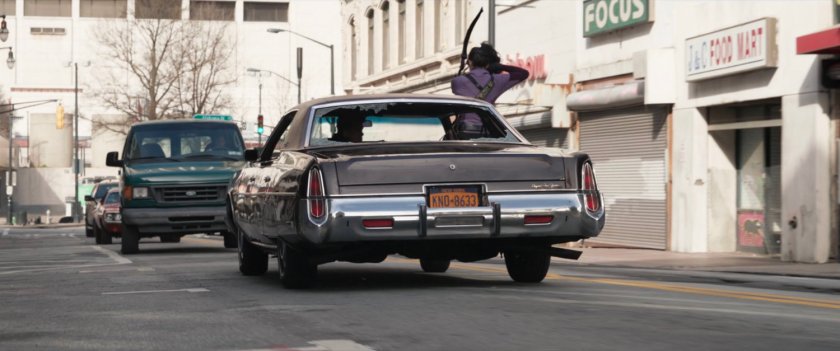 Kate fires arrows out passenger window of speeding car.