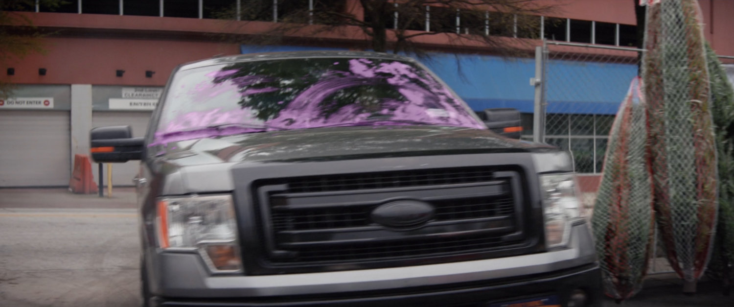 Pickup truck enters Christmas Tree lot.