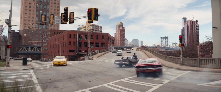 Cars speeding towards bridge entrance.