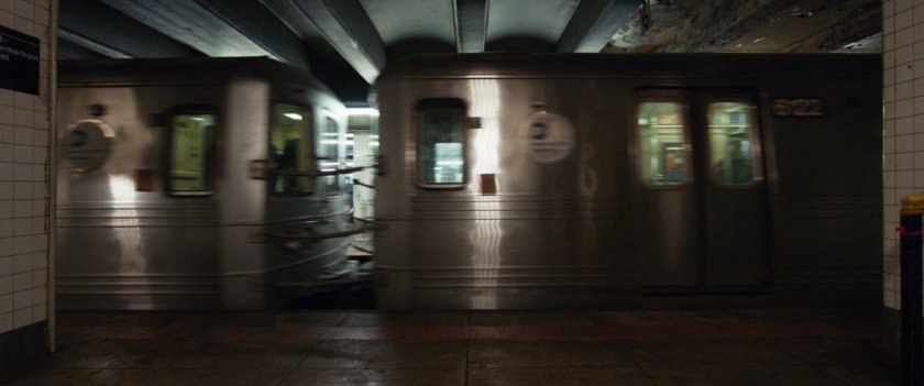 A subway train races through a subway station.