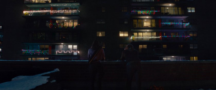 Kate and Clint on a rooftop across from Maya's apartment.