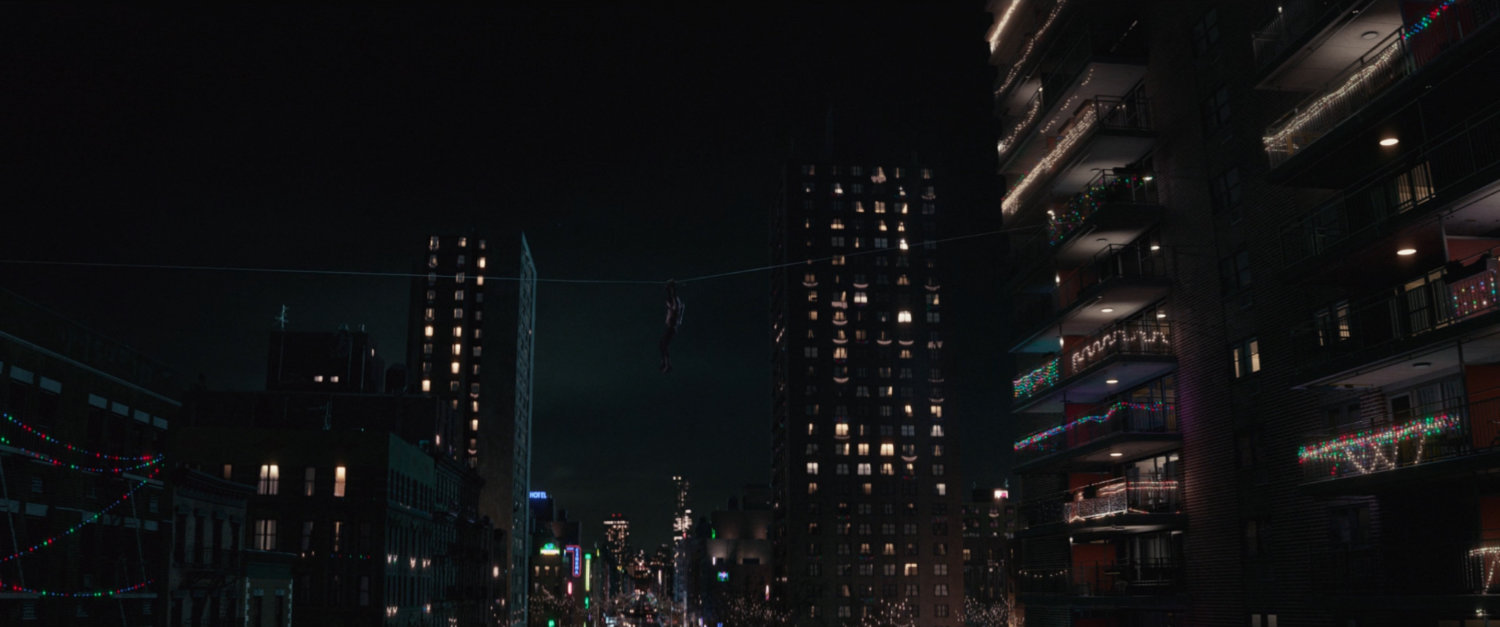 Kate suspended on wire between buildings.
