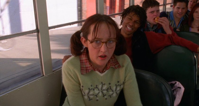 Girl with glasses on school bus.