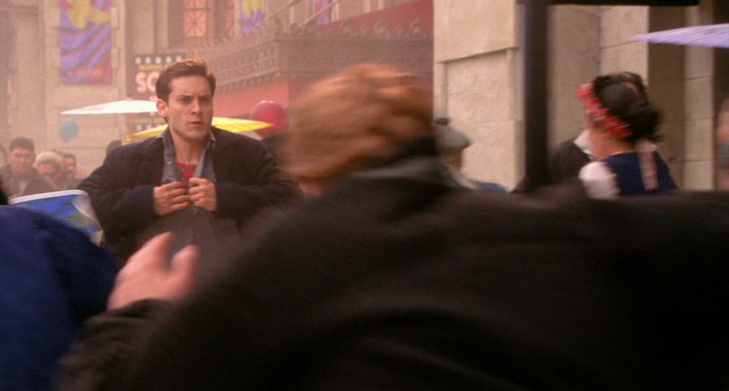 Peter Parker pulls his shirt open to reveal costume underneath.