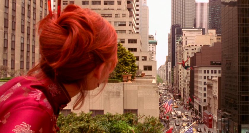 Mary Jane watching Spider-Man swing away over street.