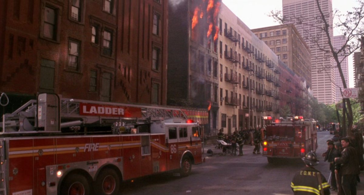Apartment on fire with fire trucks on New York street.