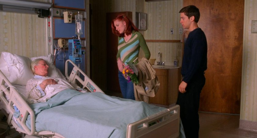Peter Parker and Mary Jane look over Aunt May in hospital bed.