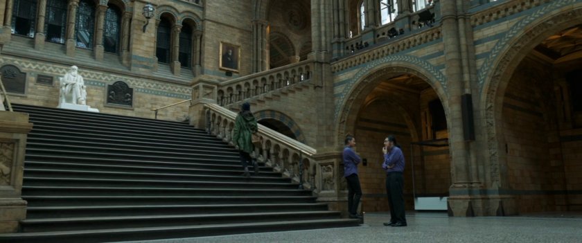 Sersi walking up stairs towards Charles Darwin statue inside of the Oxford Museum of Natural History.
