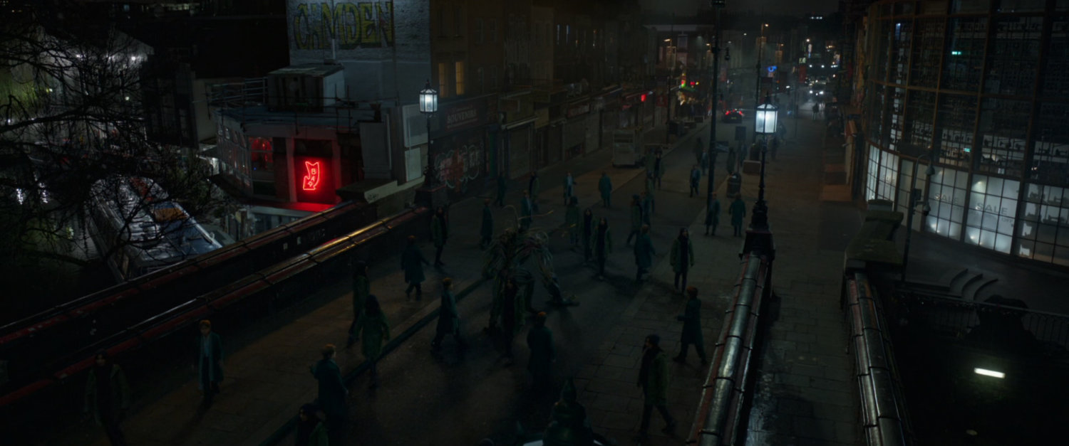 Pedestrians on a Camden bridge at night.