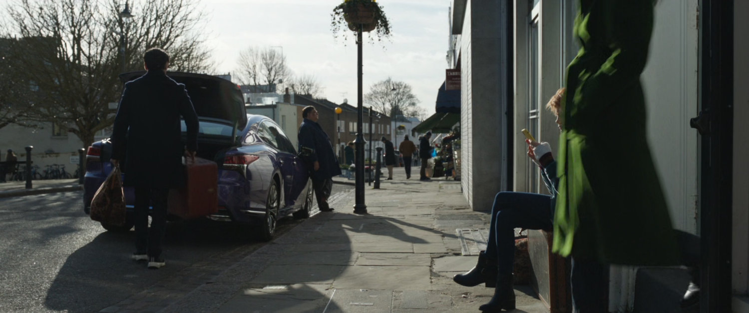 Car parked in front of row home in London.
