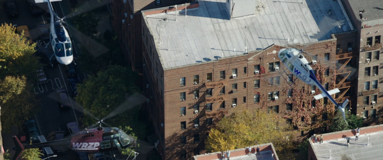 Aerial of Queens apartment building with news helicopters hovering around.