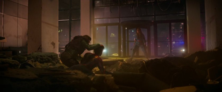 Green Goblin lifts Spider-Man's head up as May looks on in decimated lobby of Long Island City apartment building.