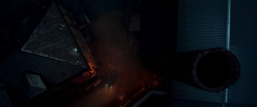 Aerial view of street next to factory tower.