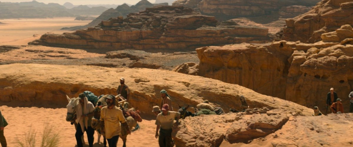 Men with donkeys walking over rocks in the Egyptian desert.