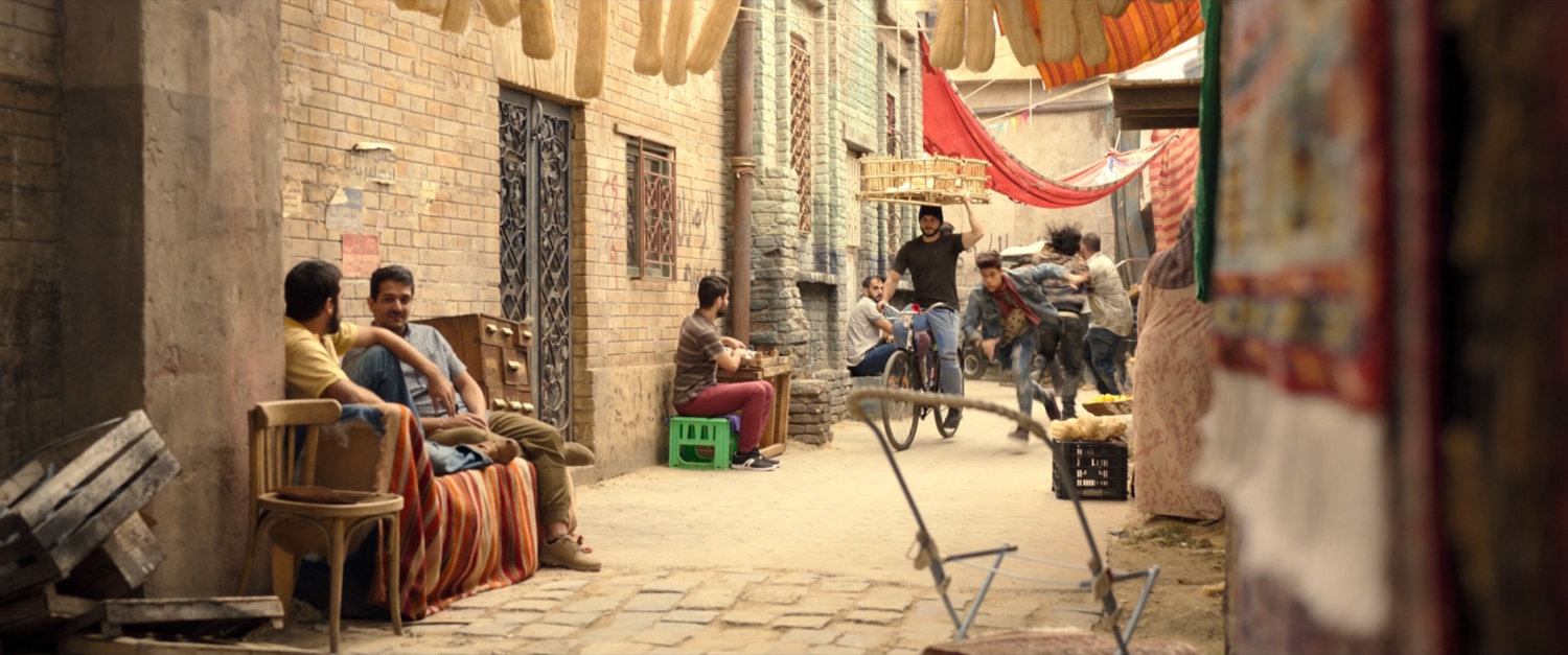 Mark chasing man through alleyway of Cairo marketplace.