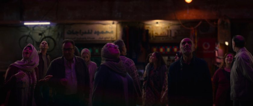 Nighttime shot of pedestrians in Cairo marketplace.