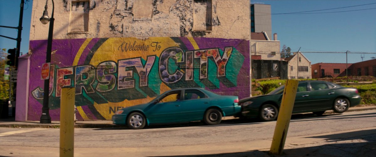 Cars in front of Welcome to Jersey City mural.