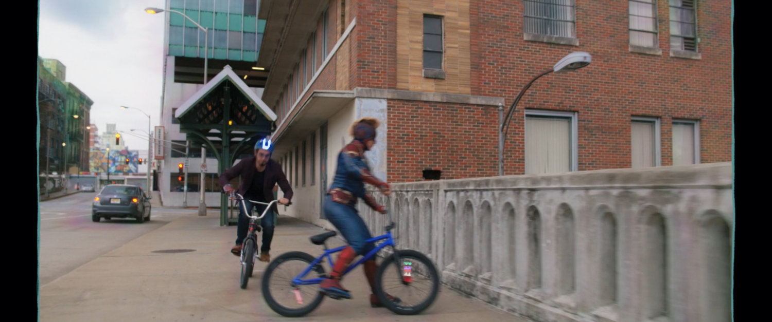 Kamala and Bruno on their bikes looking over bridge rail.