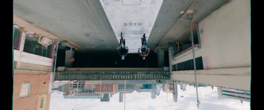 Upside down image of Kamal and Bruno riding bikes on top of bus.