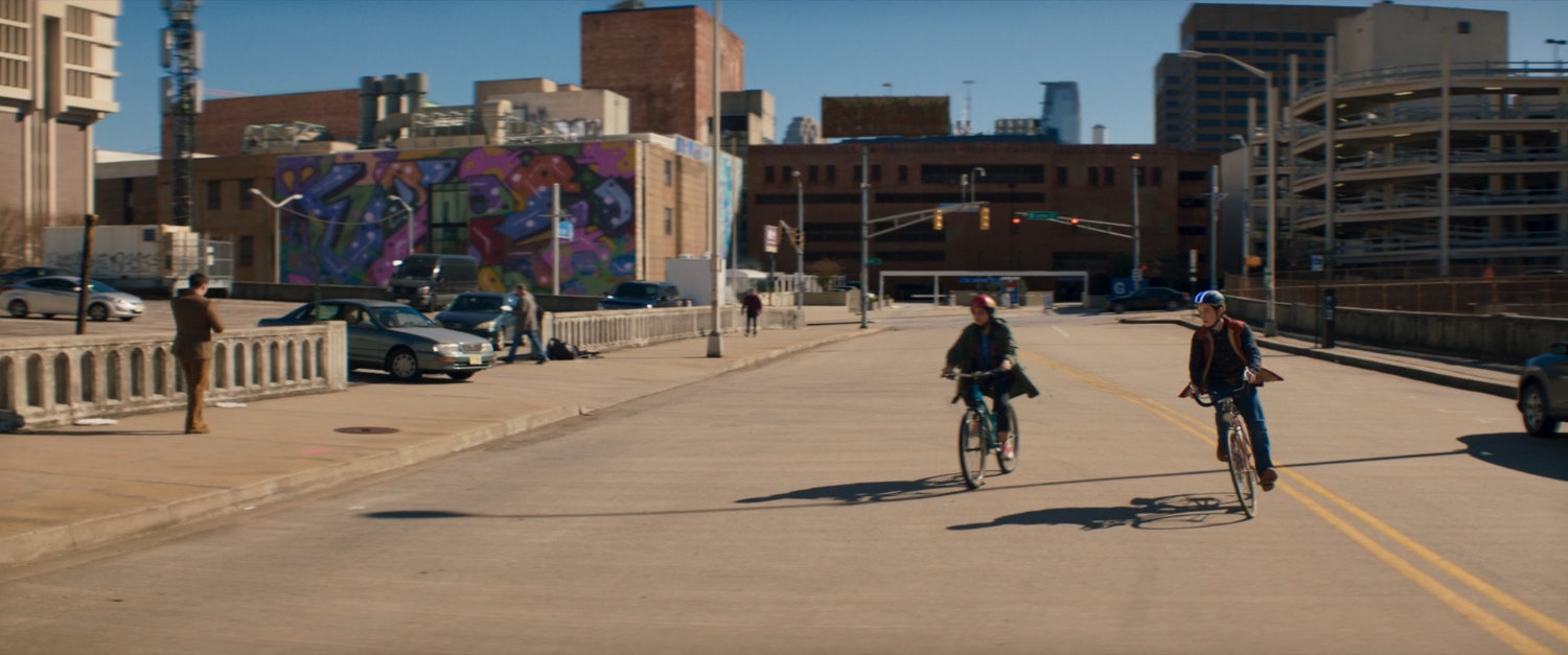 Kamala and Bruno riding their bikes on a street.