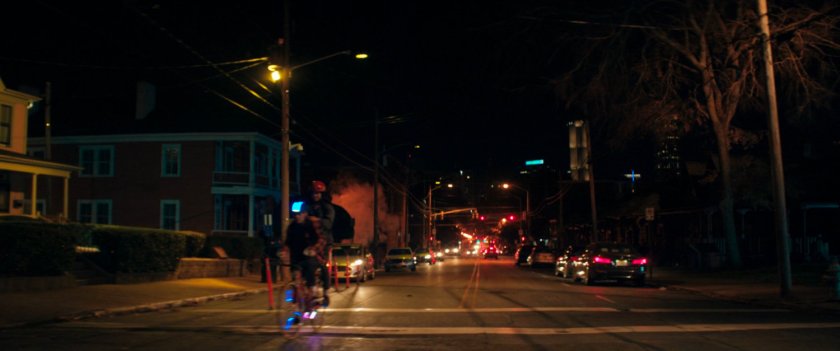 Kamala bikes through Jersey City neighborhood at night.