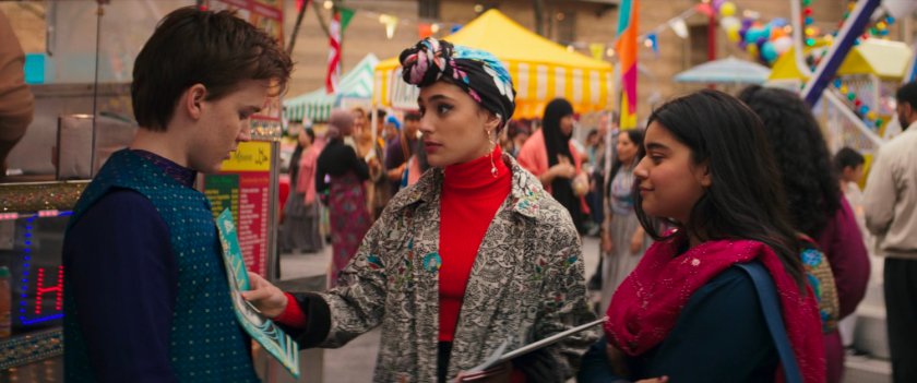 Nakia hands out fliers to Bruno and Kamala at the Eid Mubarak Fair.