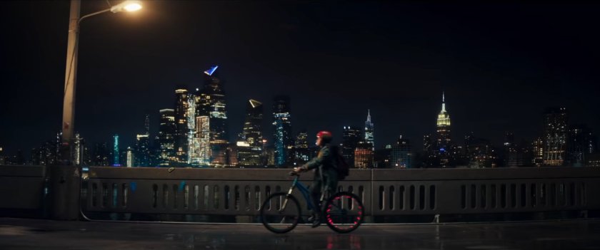 Kamala sitting on her bike on a bridge at night.