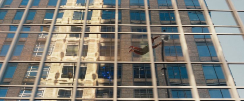 Ms Marvel's reflection on a skyscraper as she flies past.